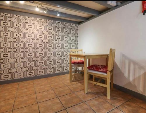 a room with a table and a chair next to a wall at Coastal Village Cottage in Talacre