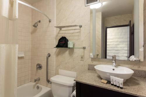 ein Badezimmer mit einem Waschbecken, einem WC und einer Badewanne in der Unterkunft Red Lion Hotel Monterey in Monterey