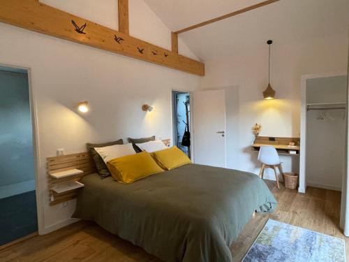 HARITZAGA chambre d'hôte avec terrasse في بياريتز: غرفة نوم بسرير كبير مع مخدات صفراء