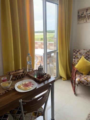 een kamer met een tafel met een bord eten erop bij appartement face du mere in Tanger