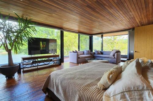 Un dormitorio con una cama grande y una sala de estar. en Maremansa Lake House Guatapé, en Chiquinquirá
