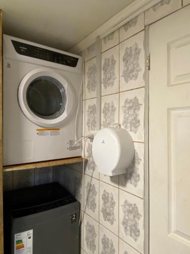 Una lavadora y secadora en una cocina con pared en Habitación para 4, acogedor, familiar, equipado, baño compartido 