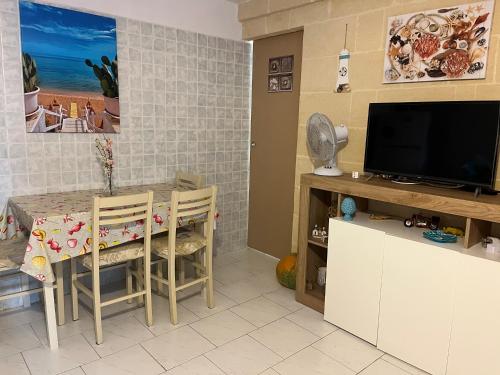 CampomarinoにあるCasa vacanze Brezza di mareのテーブルとテレビのあるリビングルーム