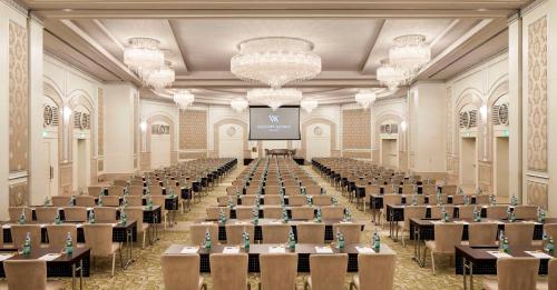 a large room with tables and chairs and a screen at Waldorf Astoria Jerusalem in Jerusalem