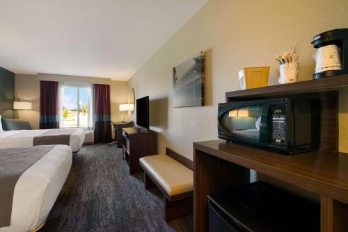 ein Hotelzimmer mit einem Bett und einem TV in der Unterkunft Best Western Roosevelt Place in Bismarck