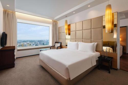 a bedroom with a large white bed and a large window at Radisson Blu Hotel Ranchi in Rānchī