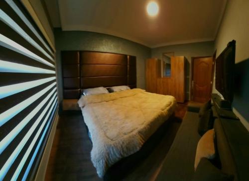een slaapkamer met een groot bed en een raam bij عمارة اوركيدا in Amman