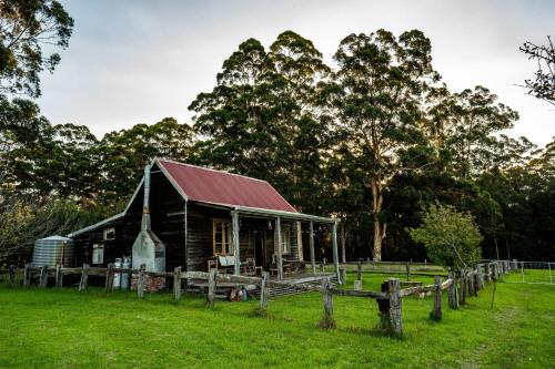 an old barn with a fence in front of it at Cosy Farmstay: Green Cabin at Whispering Woods in Beedelup