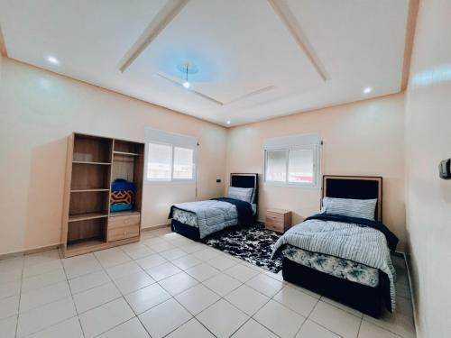 a bedroom with two beds and a closet at RÉSIDENCE SNIYA in Dakhla