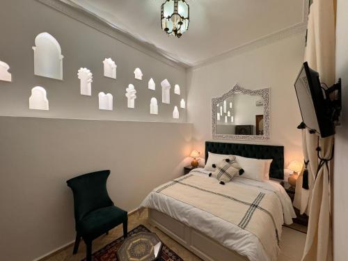 a bedroom with a bed and a mirror and a chair at Riad Al-Qurtubi in Tangier