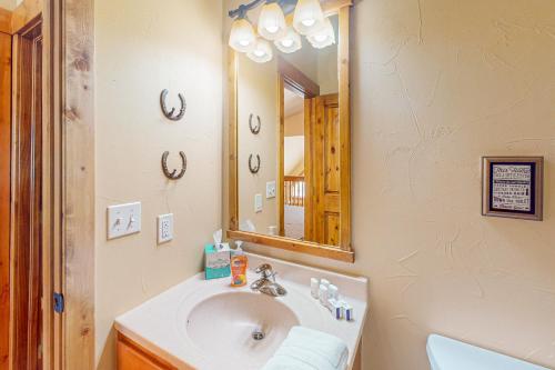 a bathroom with a sink and a mirror at Spruce Chalet in Granby