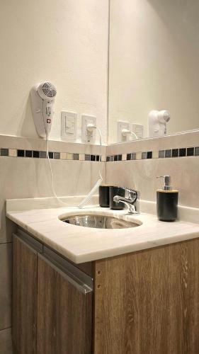 a bathroom counter with a sink and a mirror at Balcón Edén Apart in La Falda