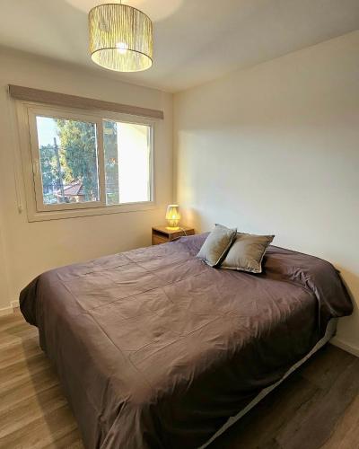 a bedroom with a large bed with a window at Balcón Edén Apart in La Falda