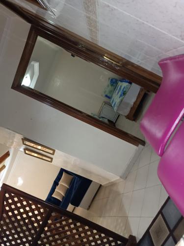 une chaise rose dans une pièce avec un miroir dans l'établissement Quartier riad résidence riad, à Ifrane