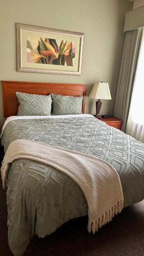a bedroom with a bed and a lamp and a window at Desert Canyon Golf Resort in Orondo