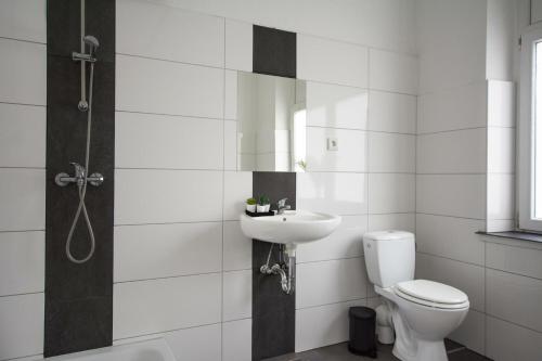 ein weißes Badezimmer mit Toilette und Waschbecken in der Unterkunft T&K Apartments - Apartments 20 Min to MESSE DUS in Krefeld