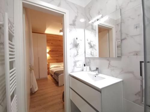 baño con lavabo, espejo y cama en Casa di Kaixin, en Mestre