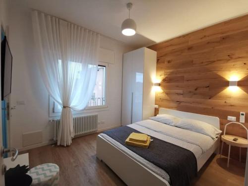 1 dormitorio con 1 cama grande y pared de madera en Casa di Kaixin, en Mestre