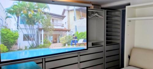 a flat screen tv in a room with a swimming pool at IH Apartments & Studios in Espinho