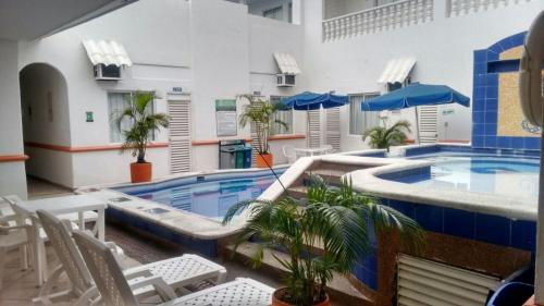 una gran piscina en un edificio con sillas en Hotel Bucaros, en Espinal