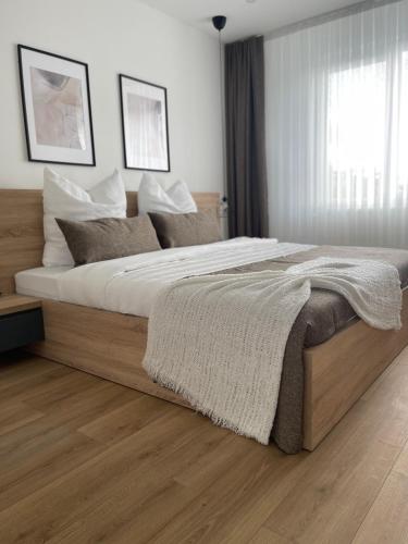 - une chambre avec un grand lit et des draps blancs dans l'établissement U-sleep : appartement 2 chambres, à Liège