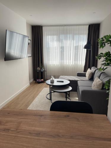- un salon avec un canapé et une table dans l'établissement U-sleep : appartement 2 chambres, à Liège
