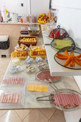 a buffet line with many different types of food at Pousada Sol da Enseada Guarujá Inn - Piscina Aquecida in Guarujá