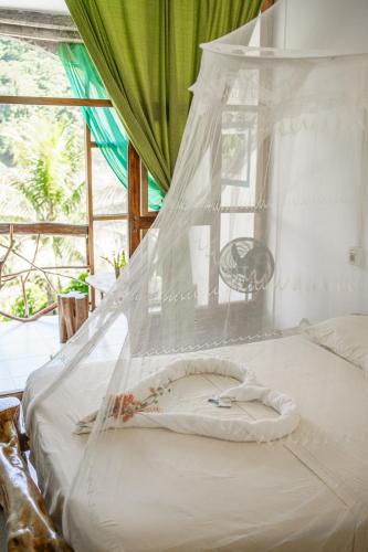 a bed with a net on top of it at Lobo Hostel - Rurrenabaque in Rurrenabaque