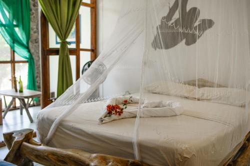 a hammock bed with flowers on it in a room at Lobo Hostel - Rurrenabaque in Rurrenabaque