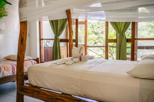 a bedroom with a bed and a large window at Lobo Hostel - Rurrenabaque in Rurrenabaque