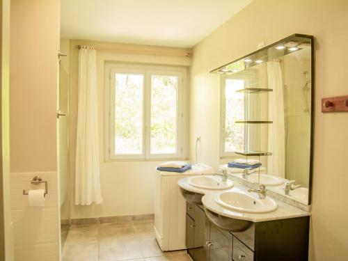 une salle de bain avec deux lavabos et une fenêtre dans l'établissement Gite Moulin de lAlbarède, à Saint-Cybranet