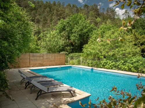 - une piscine avec des chaises longues à côté dans l'établissement Gite Moulin de lAlbarède, à Saint-Cybranet