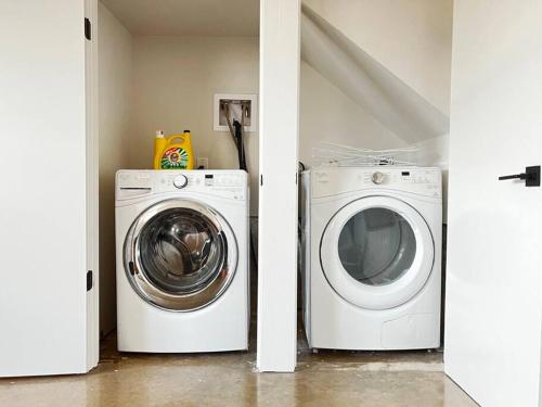 a laundry room with a washing machine and a washer at A Min Walk to 6th St I 1 BR Home in East ATX in Austin