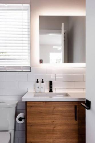 a bathroom with a sink and a toilet and a mirror at A Min Walk to 6th St I 1 BR Home in East ATX in Austin