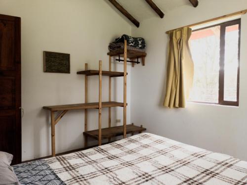 1 dormitorio con 1 cama y 2 estanterías de madera en Ataraxia - Atarixa, en Subachoque