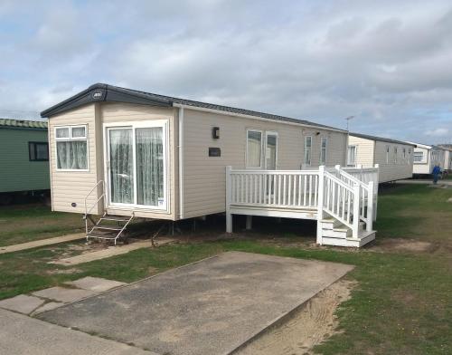 a mobile home with a porch and a staircase at Your Retreat Too in Camber