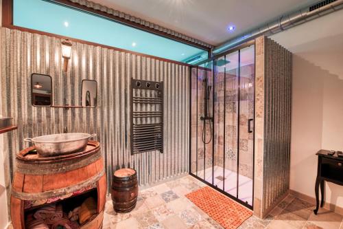 uma casa de banho com um chuveiro e um barril grande em La Remise en Forme em Entraigues-sur-la-Sorgue