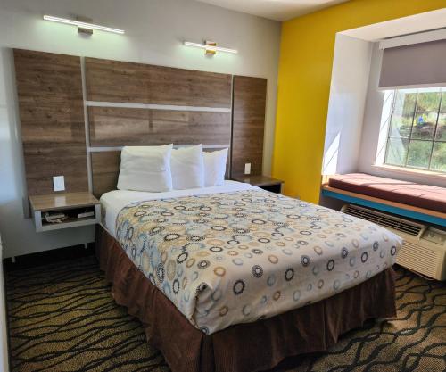 a hotel room with a large bed and a window at Desert Inn Tucumcari in Tucumcari
