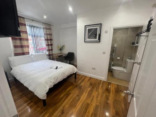 sypialnia z białym łóżkiem i łazienką w obiekcie Tarleton house w mieście Stoke-on-Trent