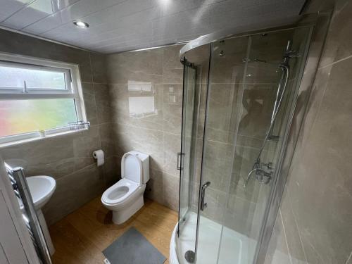 a bathroom with a toilet and a glass shower at Tarleton house in Stoke on Trent