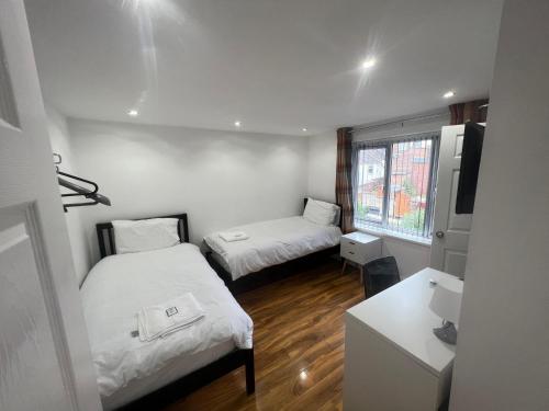 a small room with two beds and a television at Tarleton house in Stoke on Trent