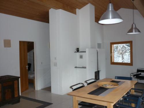 eine Küche mit einem Holztisch und einem Kühlschrank in der Unterkunft Moderne attraktive Dachwohnung für max. 6 Personen in ruhiger Umgebung in Flims