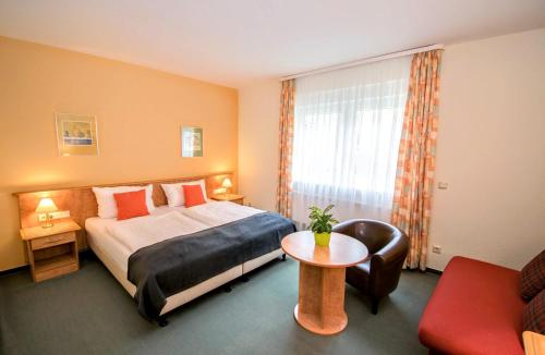 a hotel room with a bed and a table at Landhotel Ringelsteiner Mühle in Moselkern