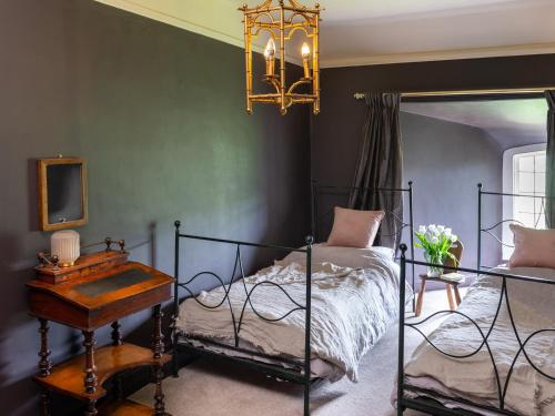 a bedroom with a bed and a table and a chandelier at Fernhill Castle in Keighley
