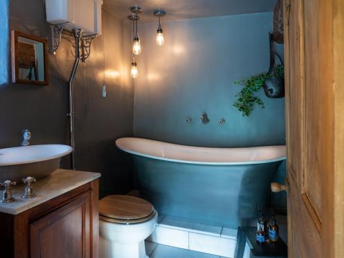 a bathroom with a tub and a toilet and a sink at Fernhill Castle in Keighley