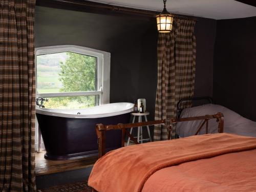 a bathroom with a bath tub and a window at Fernhill Castle in Keighley