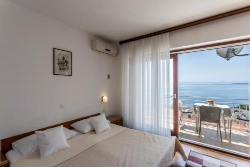 a bedroom with a bed and a view of the ocean at Apartments with parking space Baska Voda, Makarska - 301 in Baška Voda