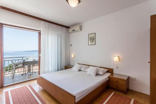 a bedroom with a bed and a large window at Studio Baska Voda 301c in Baška Voda