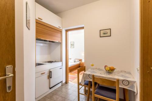 eine kleine Küche und ein Esszimmer mit einem Tisch und Stühlen in der Unterkunft Studio Baska Voda 301c in Baška Voda