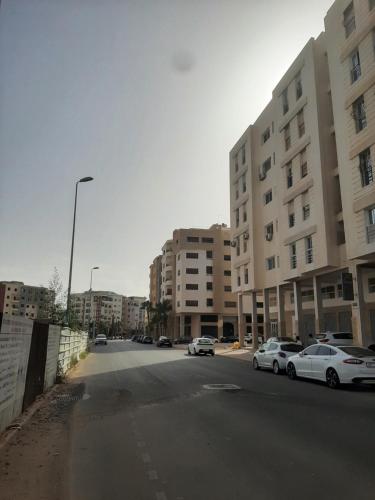 an empty street in a city with buildings and cars at Elhouda 56 in Agadir